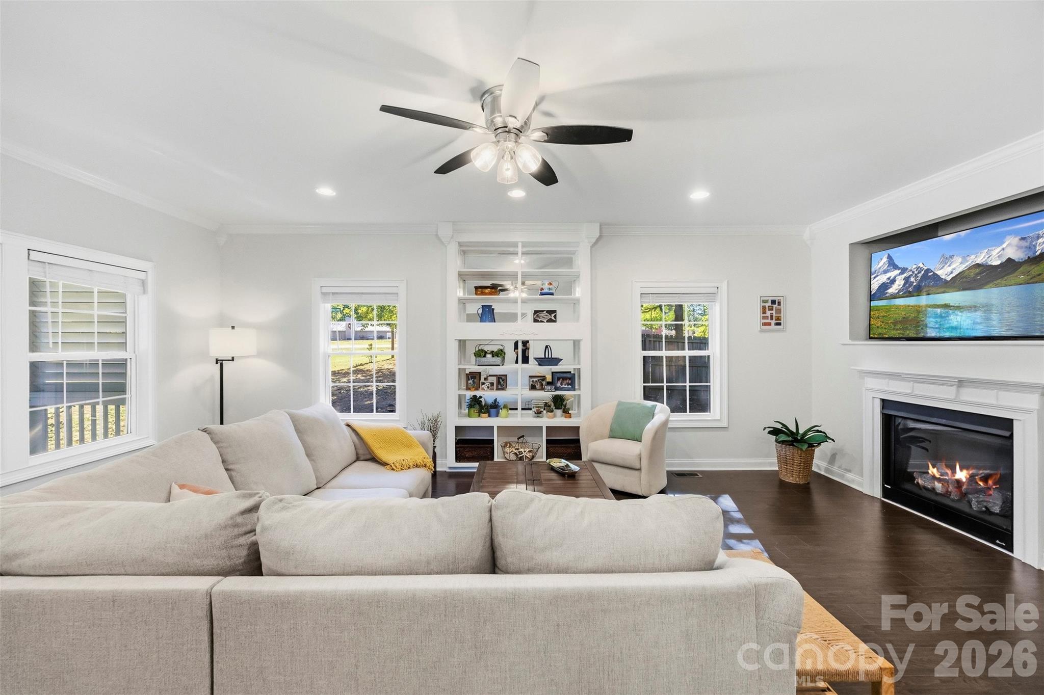Furnished living room with a sectional sofa, built-in shelves, and fireplace.