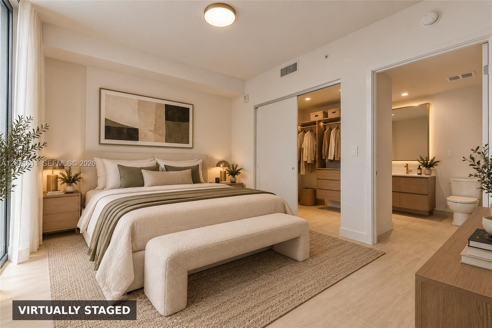 Virtually staged bedroom with a large bed, walk-in closet, and adjoining bathroom.