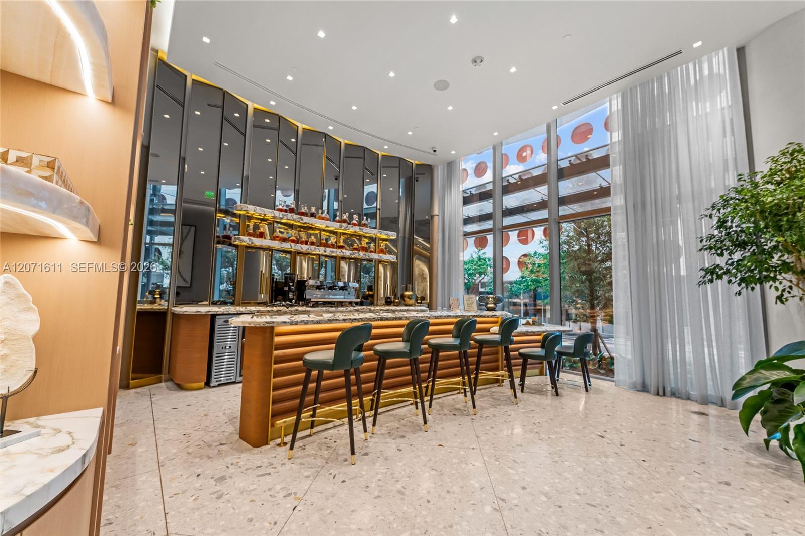 Upscale interior bar with an illuminated counter, dark stools, and floor-to-ceiling windows.