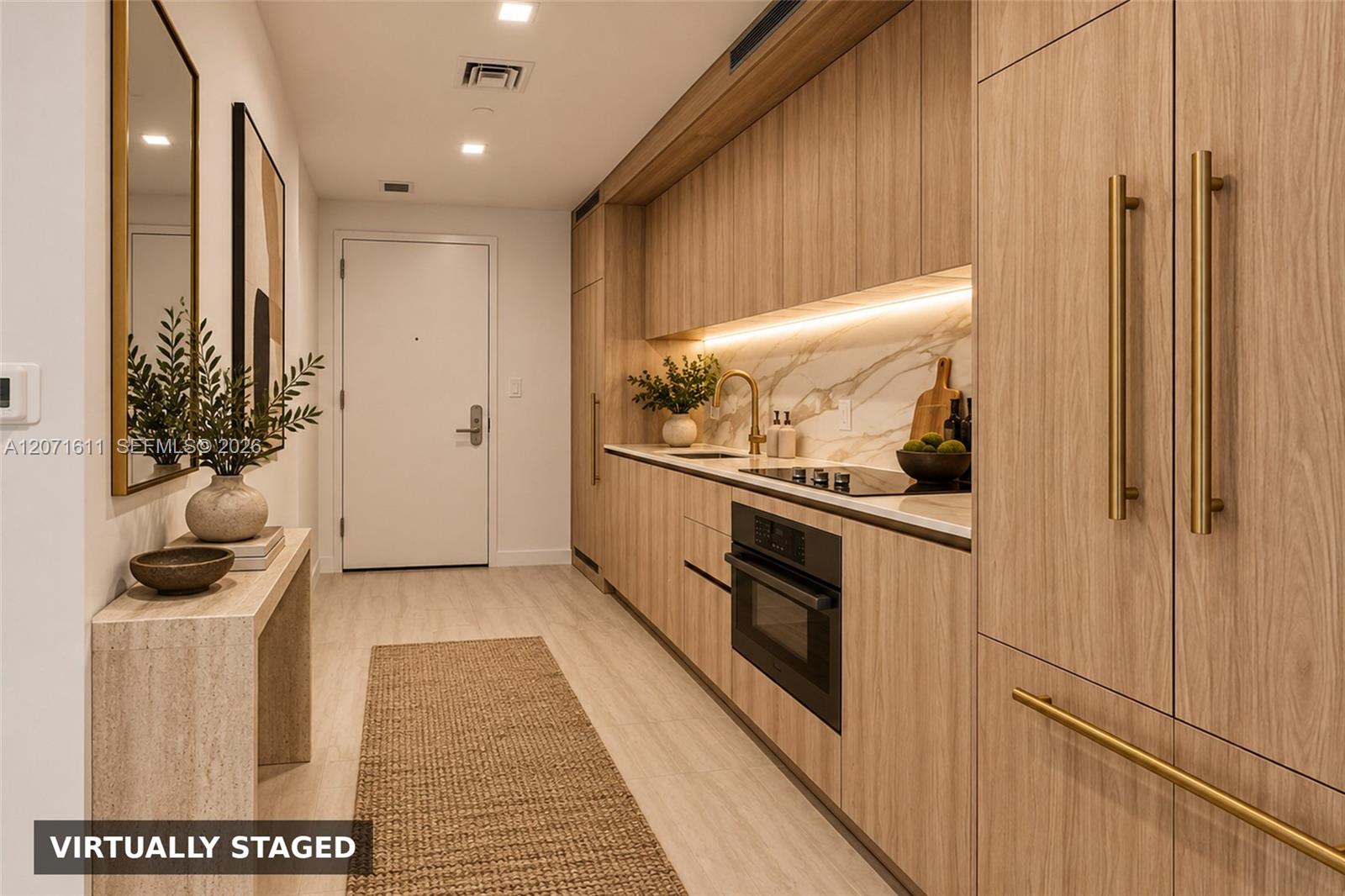 Virtually staged apartment kitchen with light wood cabinets, brass hardware, and a marble-look backsplash.
