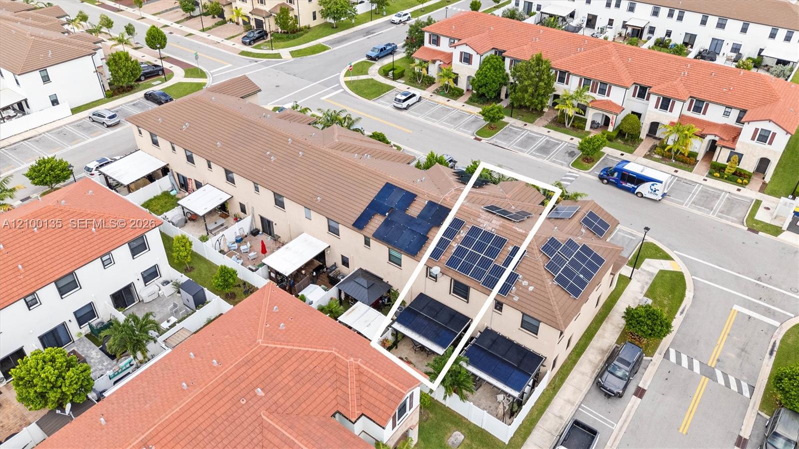 Aerial view of a townhouse outlined in white, with solar panels across its roof.