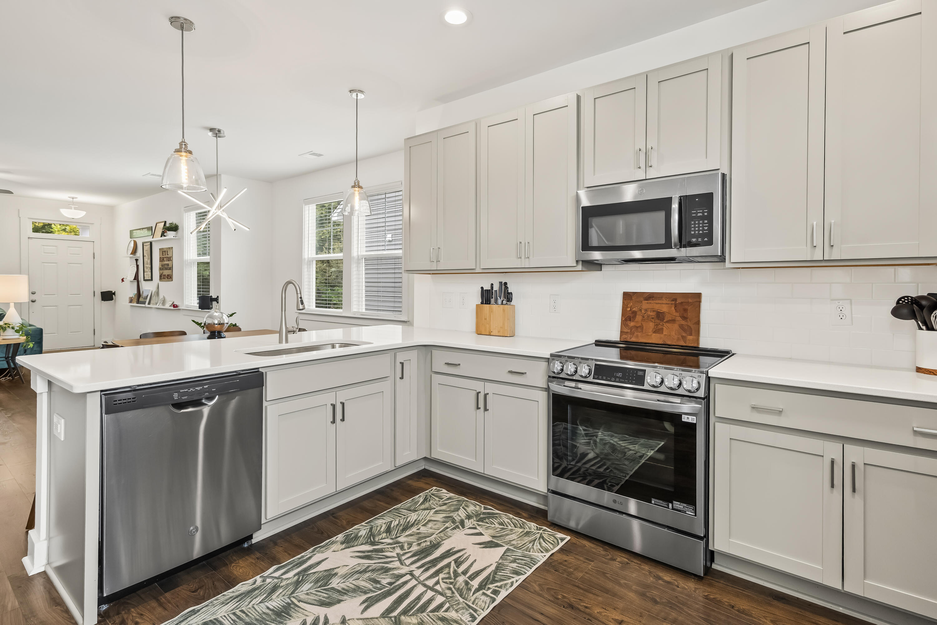 Bright kitchen with white shaker cabinets, a large peninsula, and stainless-steel appliances.