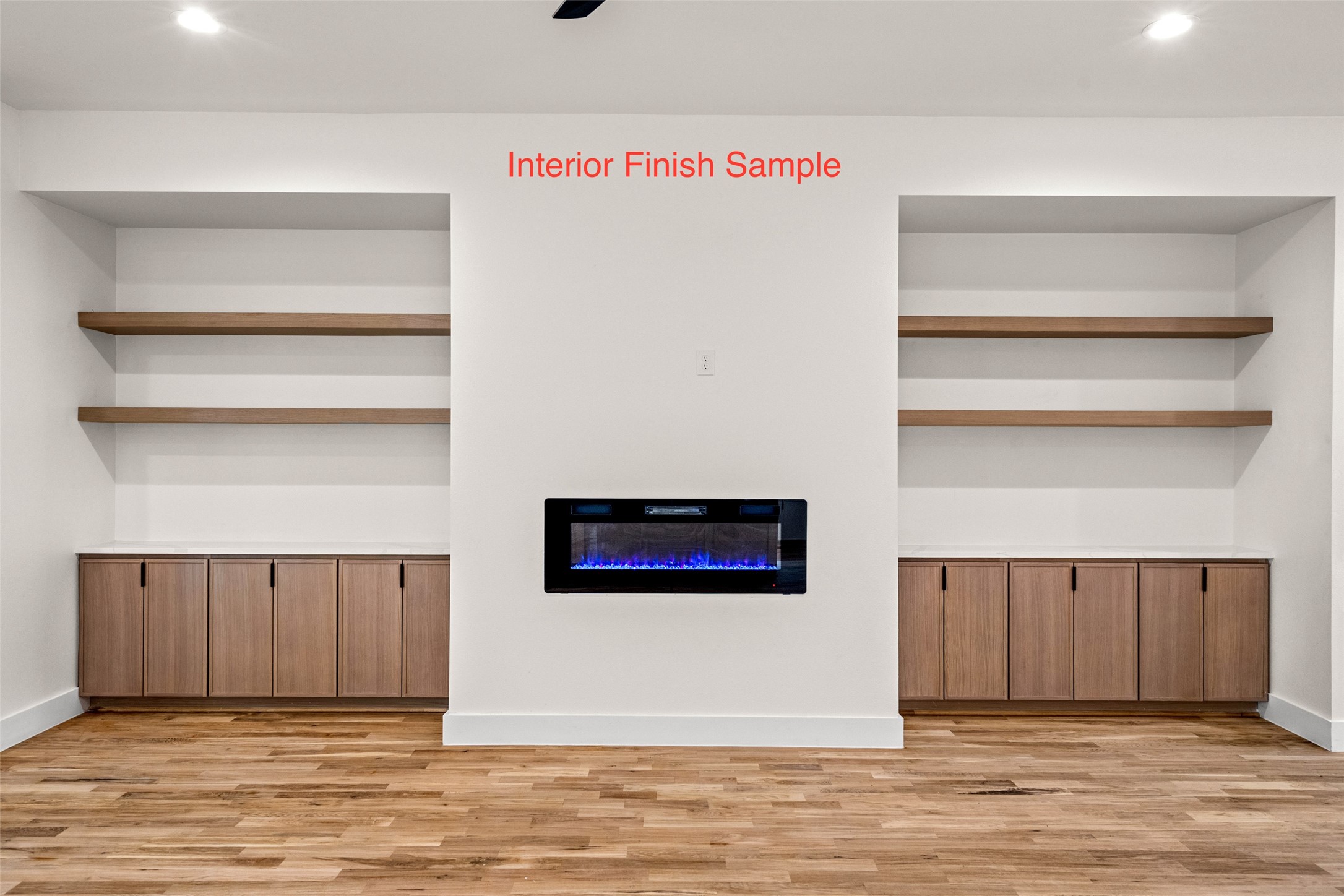 Room with a built-in electric fireplace, wood cabinets, open shelves, and hardwood floors.