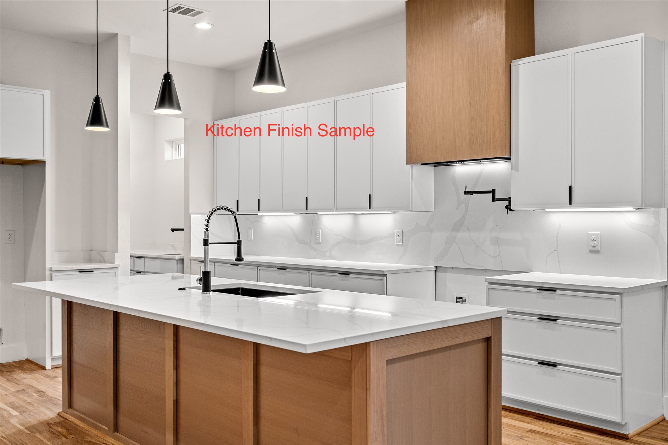 Modern kitchen with white cabinetry, veined backsplash, wood island, and black pendant lights.