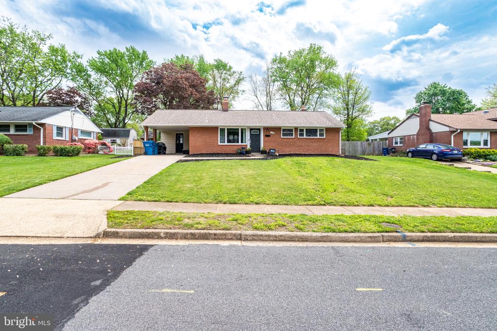 Single-story brick ranch with a broad front lawn and concrete driveway.