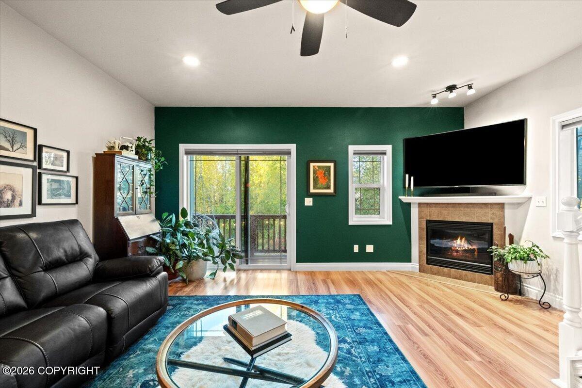 Living room with a green accent wall, fireplace, leather sofa, and sliding glass doors.