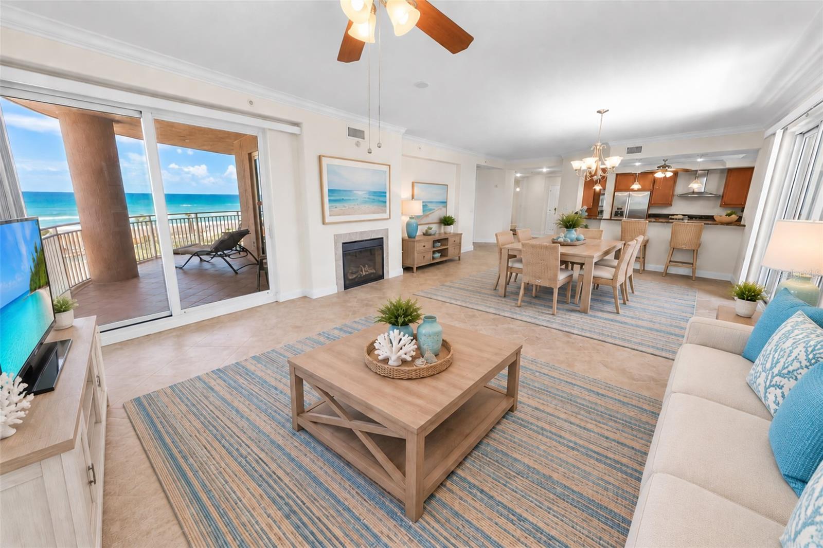 Oceanfront living and dining room with a fireplace and sliding doors to a balcony.