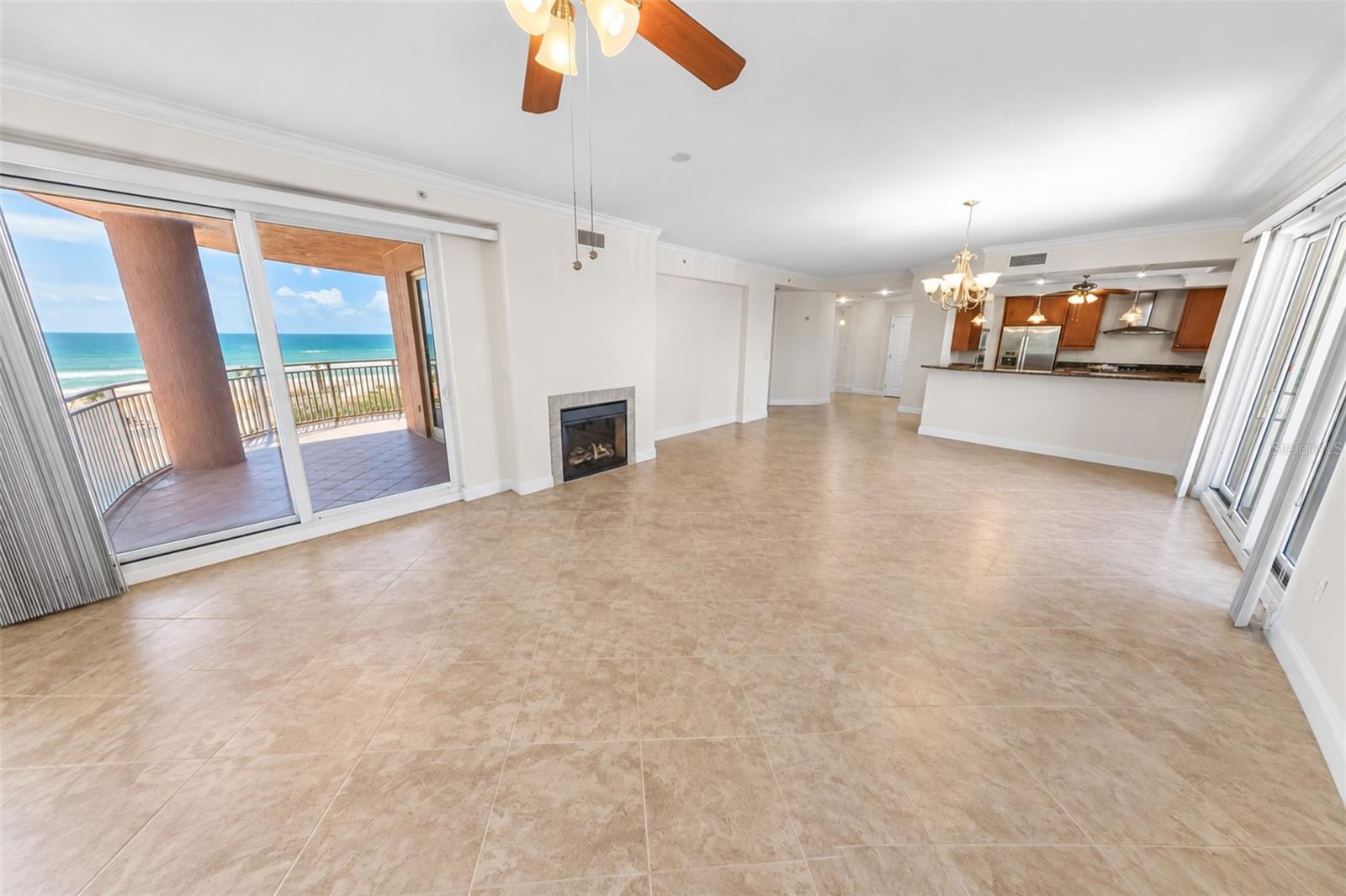 Living room with tile floors, a fireplace, and sliding doors to an ocean-view balcony.