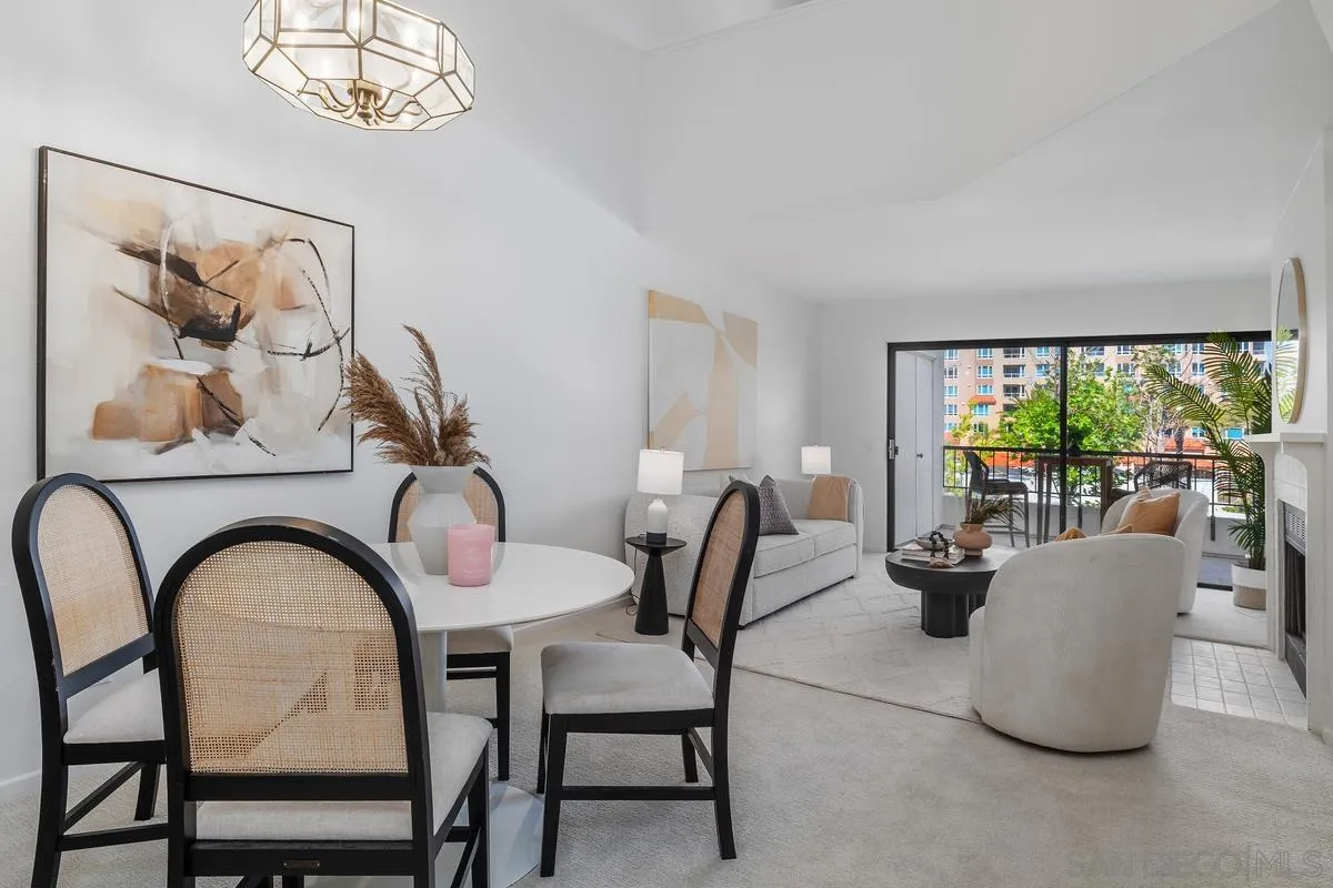 Staged open-plan living and dining room with balcony access and contemporary neutral furnishings.
