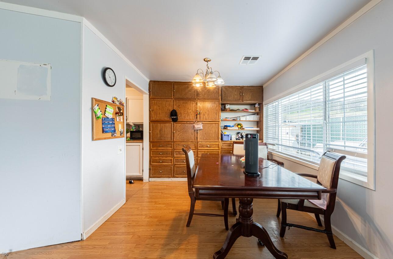 Dining room with built-in oak cabinets, a dark wood table, and wide windows with blinds.