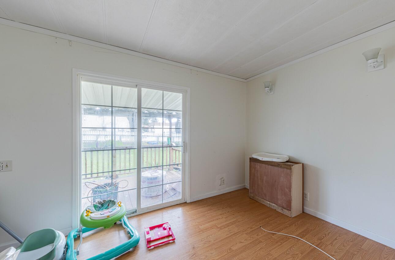 Interior room with sliding glass doors to a deck, wood-look flooring, and children’s toys.