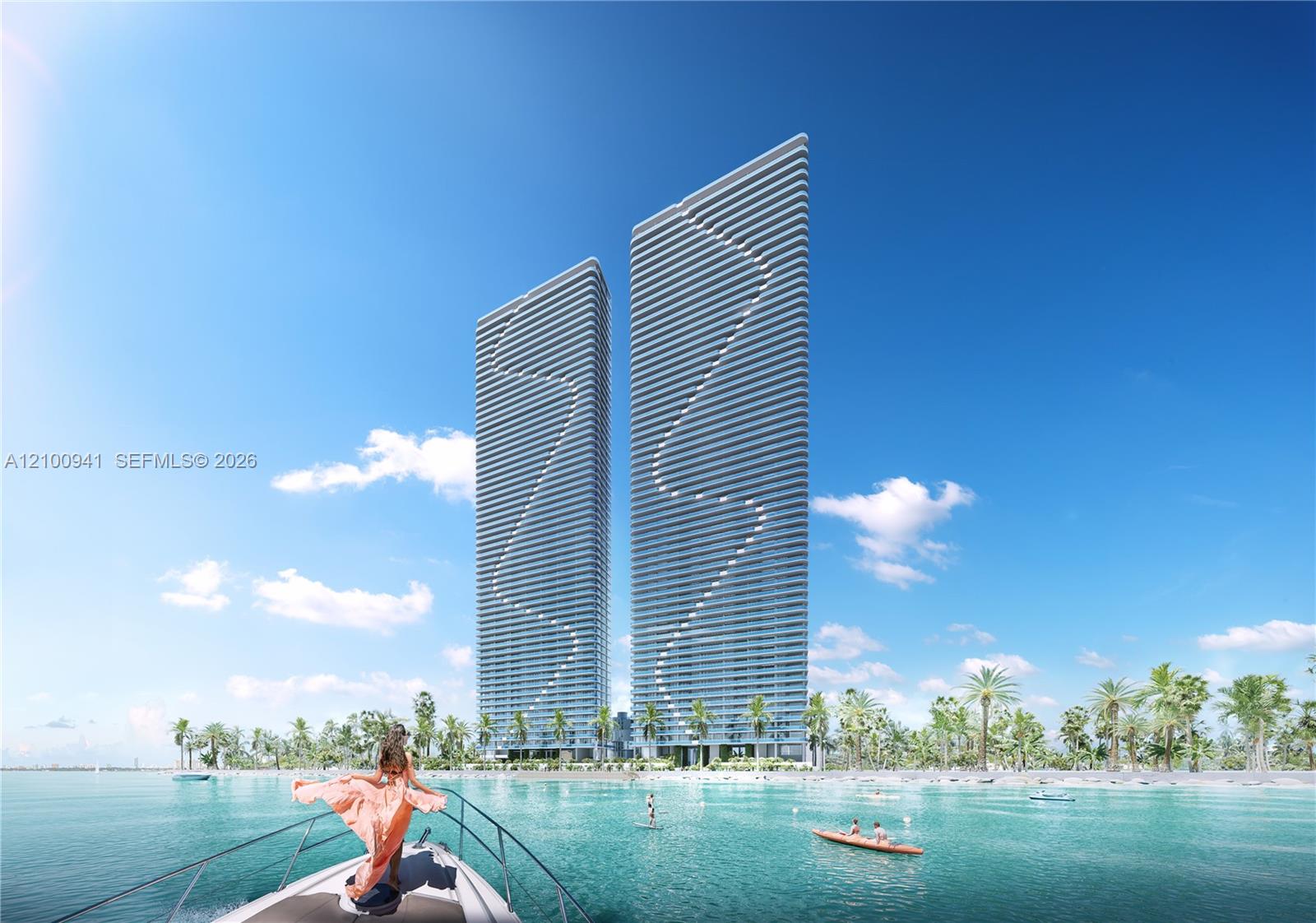 Two modern waterfront towers rise behind palm trees, viewed from a boat on turquoise water.