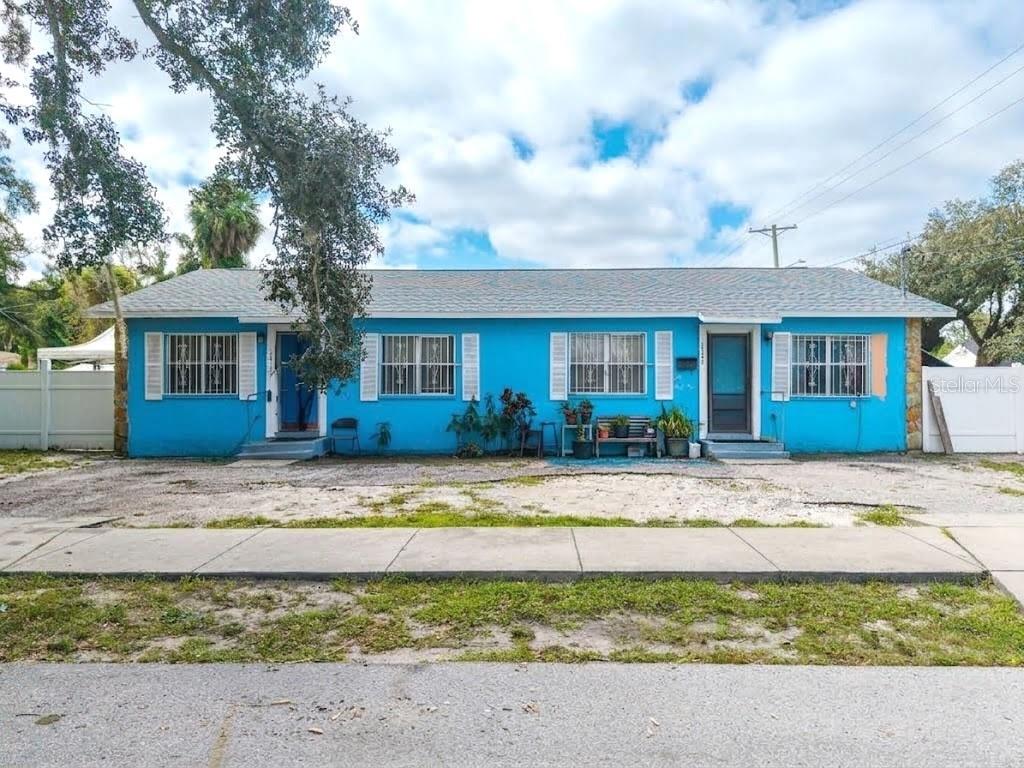 Bright blue single-story house with white shutters and two front entry doors.