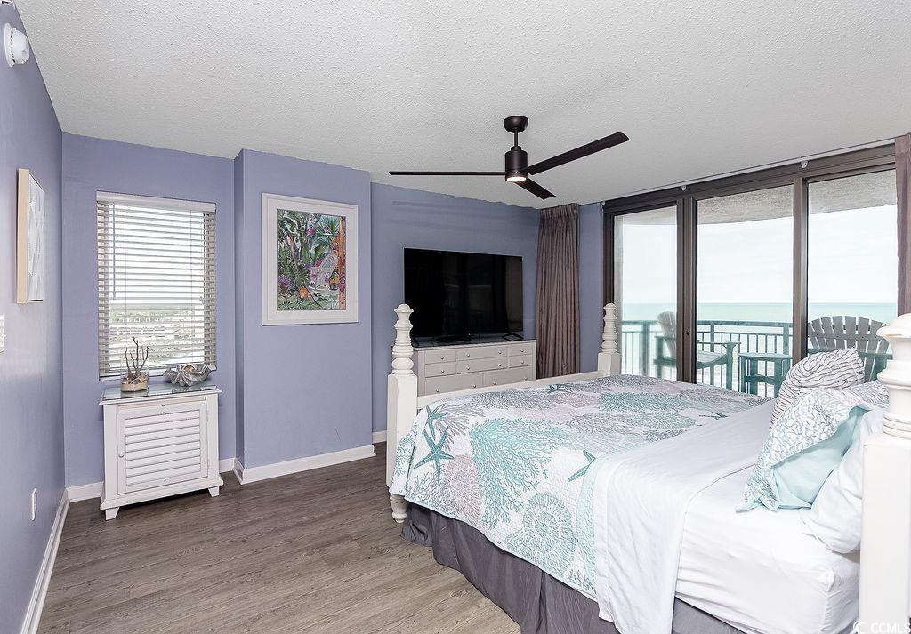 Bedroom with aqua bedding, lavender walls, and sliding doors overlooking the ocean.