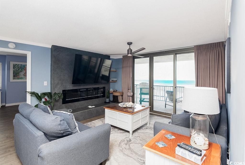 Living room with gray seating, a fireplace, and sliding doors overlooking the ocean.