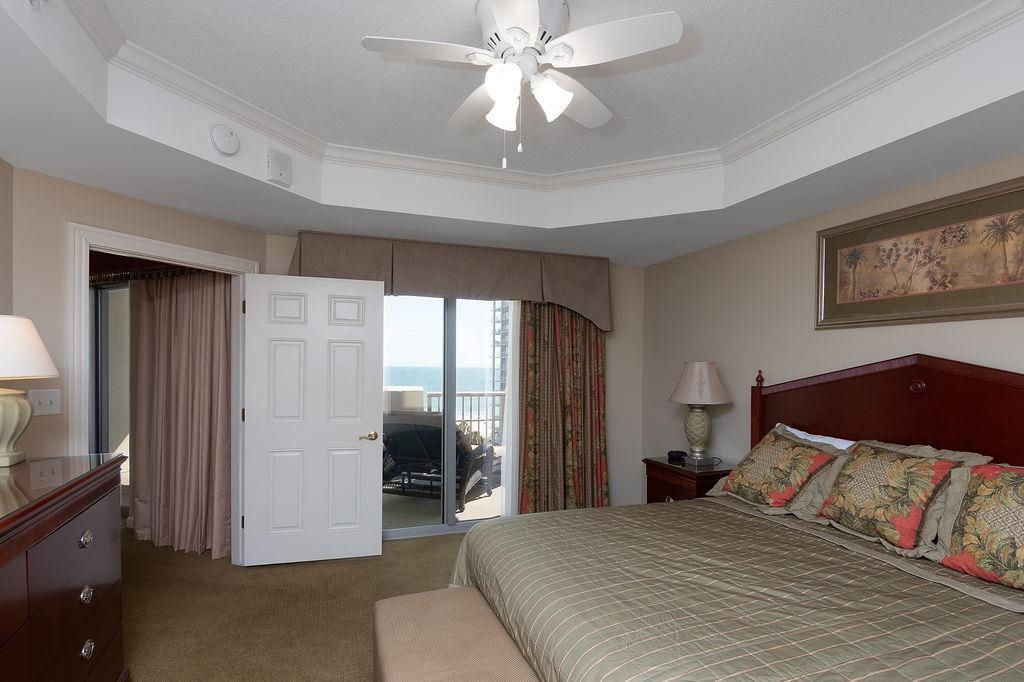 Bedroom with a large bed and sliding glass doors overlooking the ocean.
