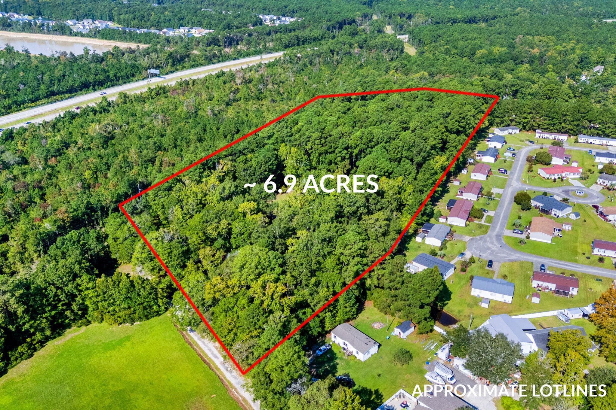 Wooded 6.9-acre parcel outlined in red beside a residential neighborhood.