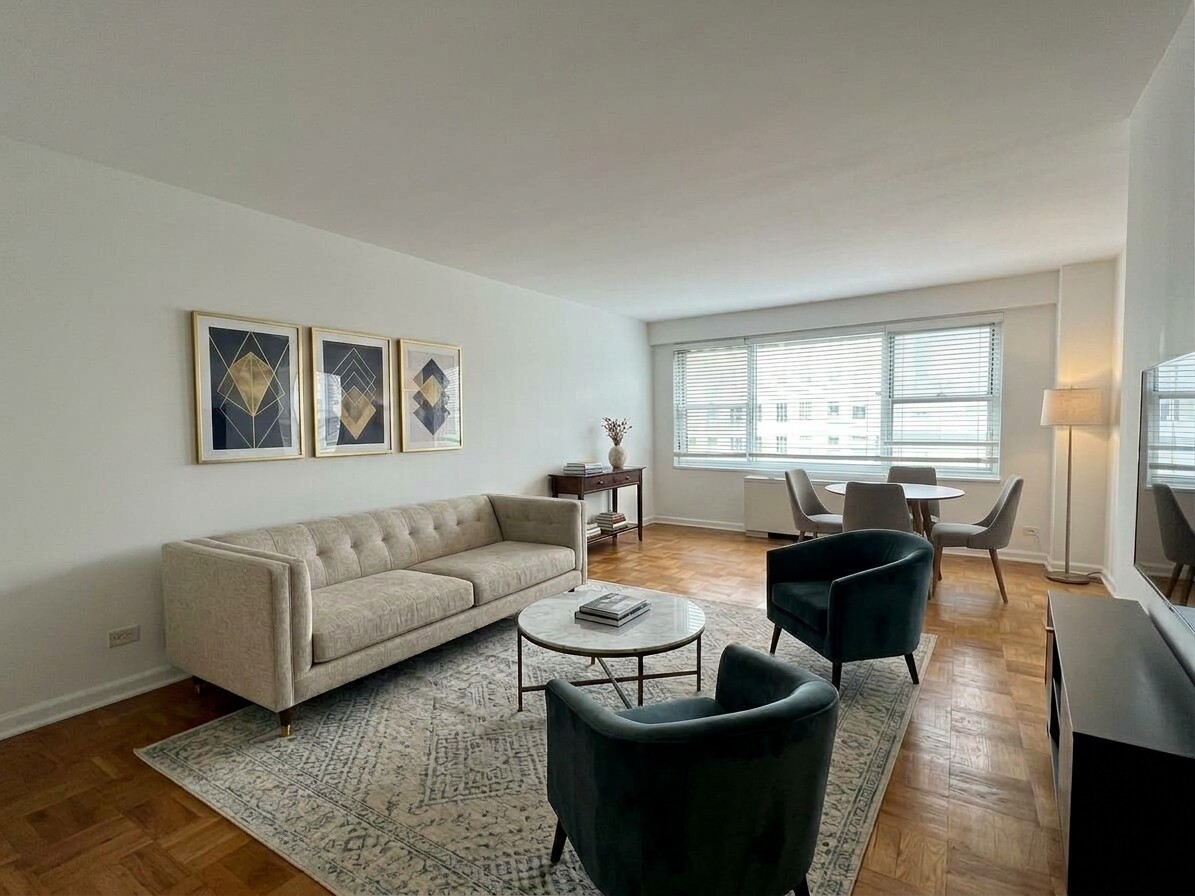 Furnished living room with parquet floors, large windows, and an adjoining dining area.