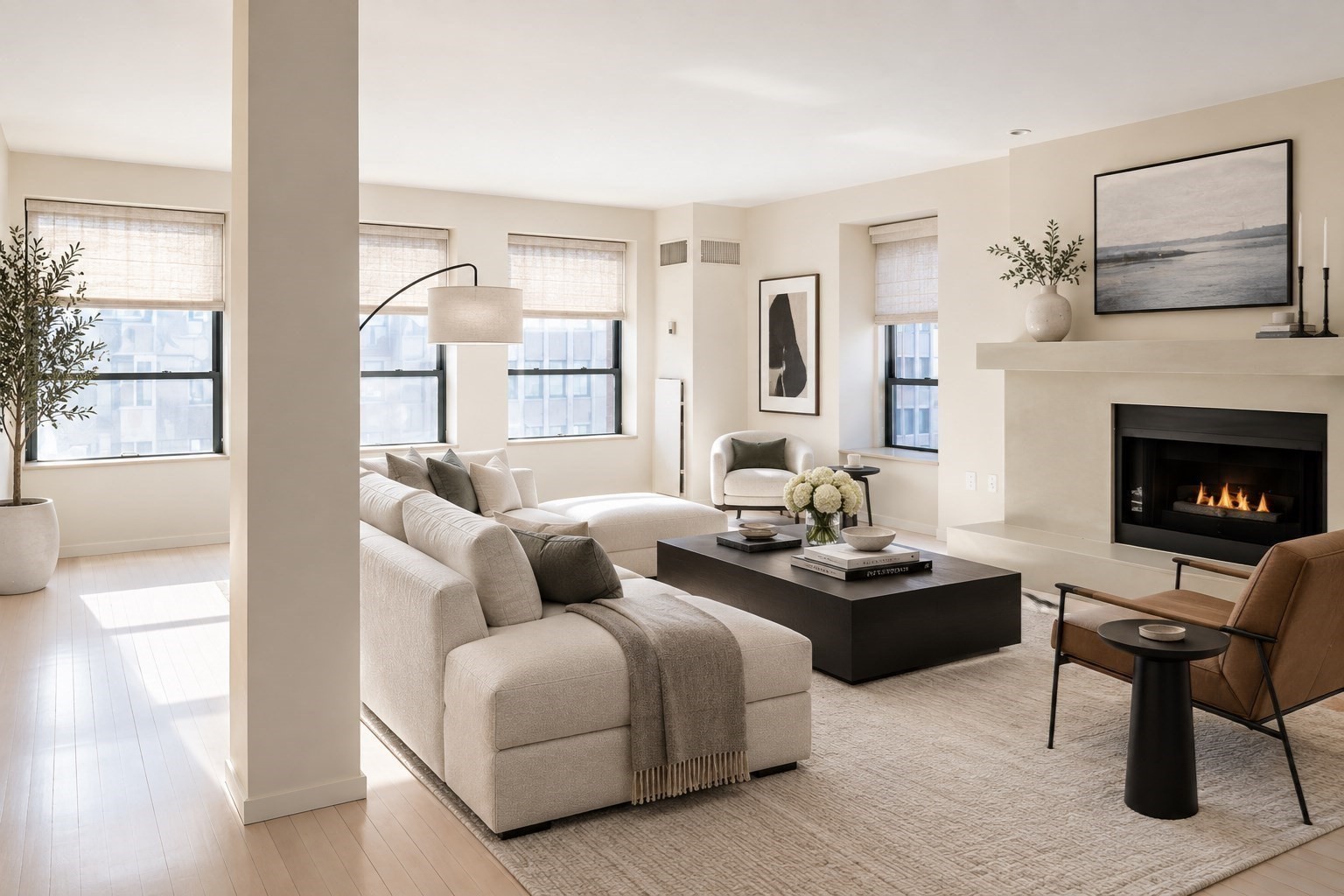 Furnished living room with a cream sectional sofa, large windows, and a modern fireplace.