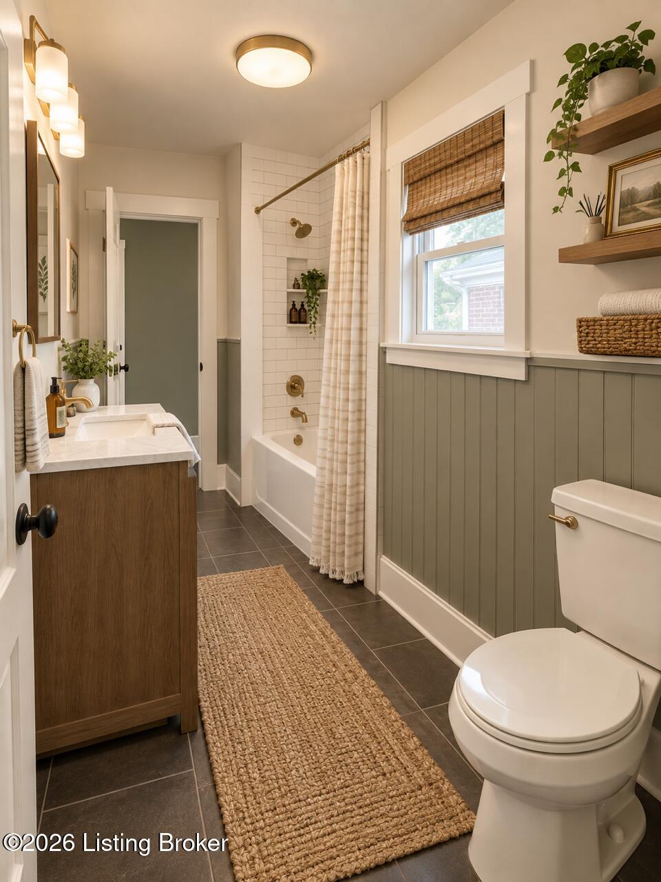 Bathroom with a wood vanity, white tub, striped shower curtain, and sage-green paneled walls.