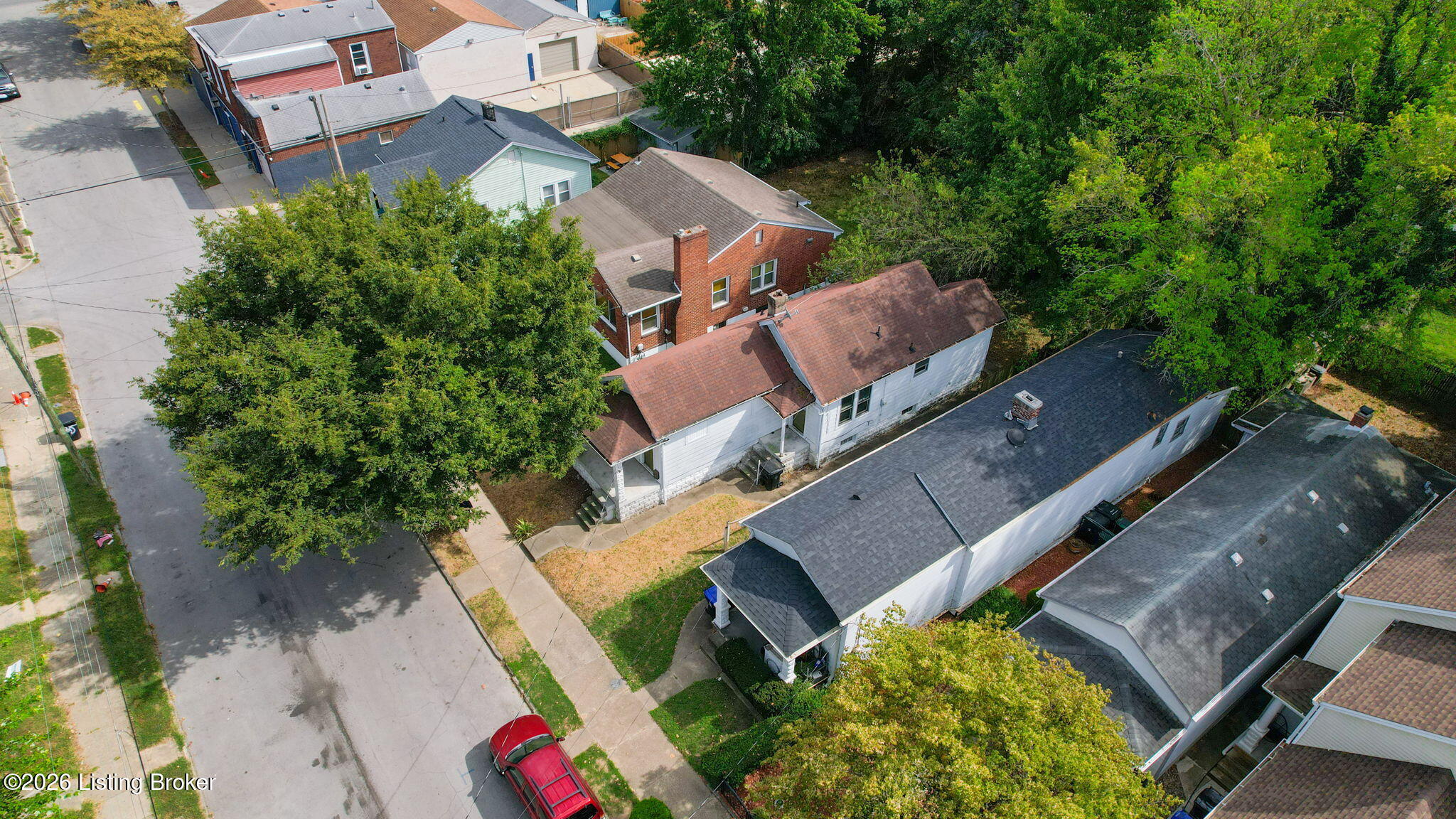 Aerial view of 720 Shelby Pkwy and neighboring homes along a tree-lined street.