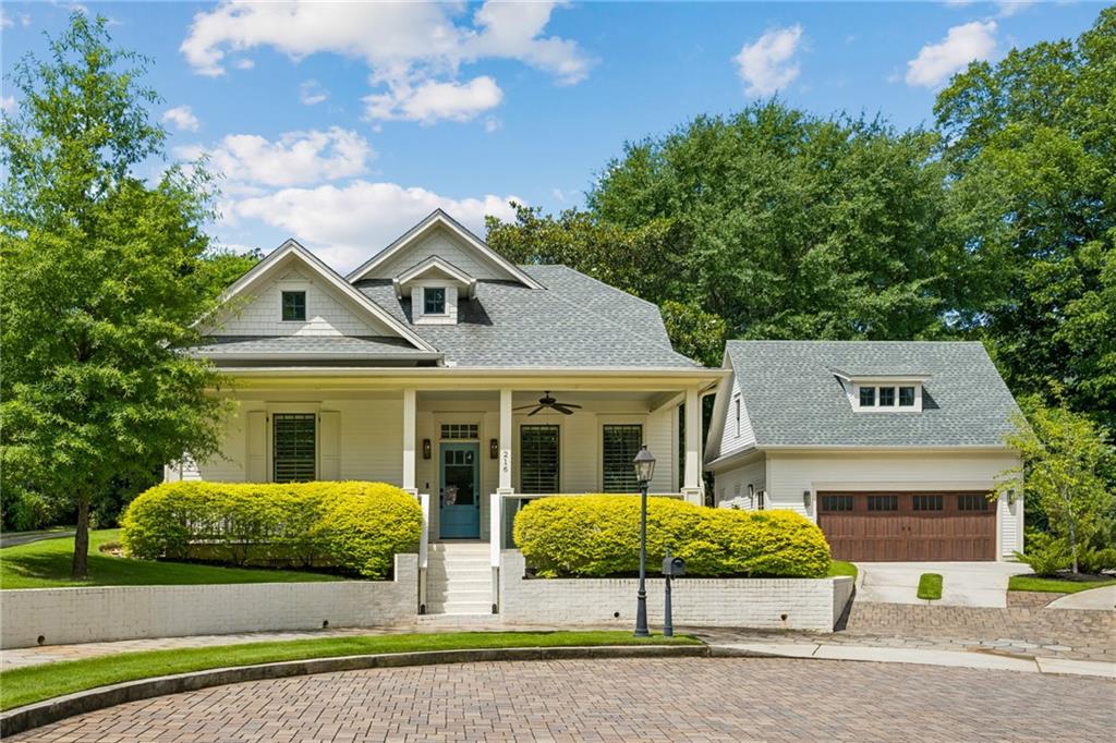 Light-colored home with a covered porch, teal front door, and attached garage.