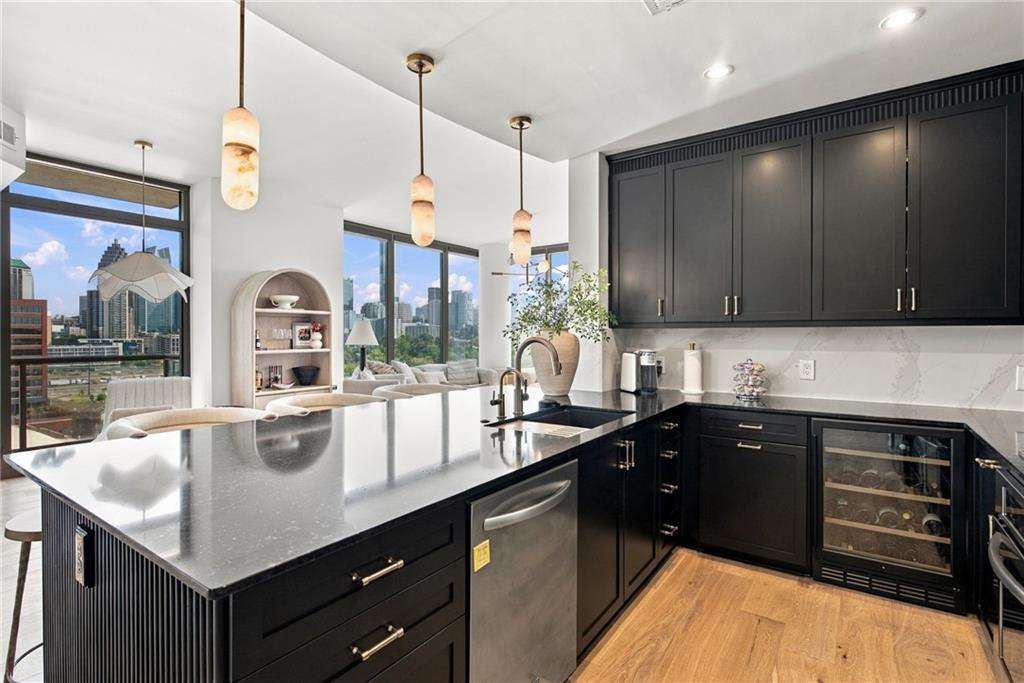 Modern kitchen with black cabinets, a large island, and Atlanta skyline views.