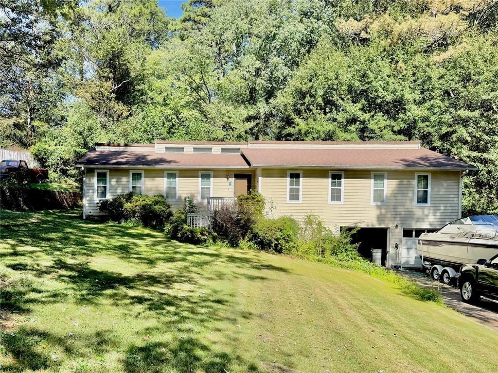 Single-story house with a small porch, attached garage, and boat in the driveway.