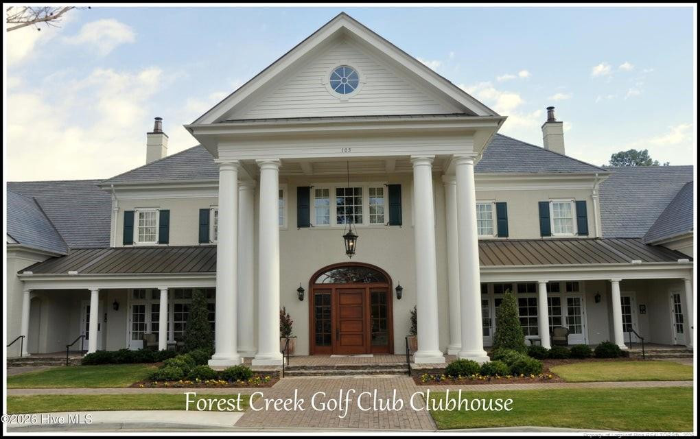 Forest Creek Golf Club clubhouse with a columned entrance and arched wooden doors.
