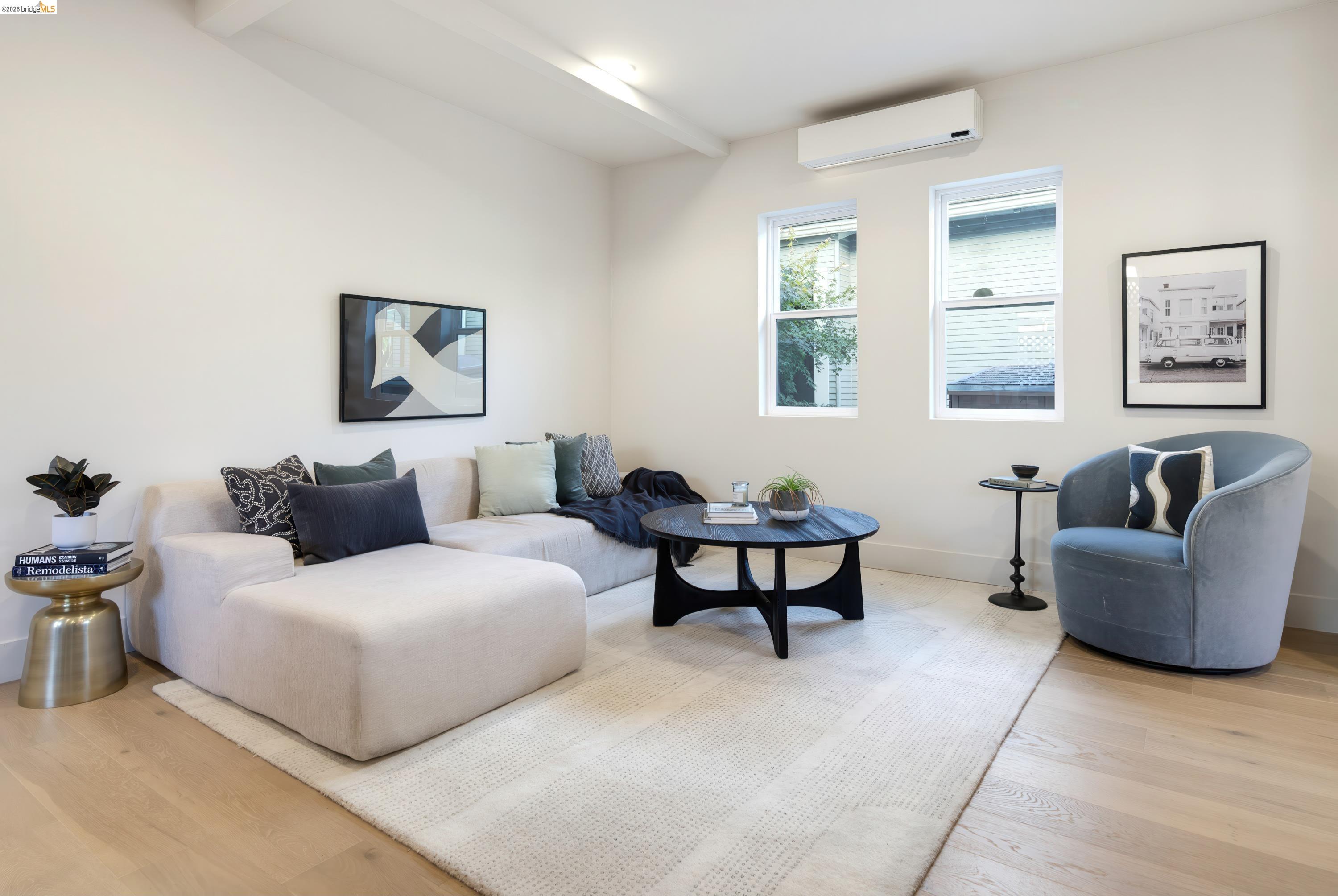Living room with a cream sectional, blue armchair, and round black coffee table.