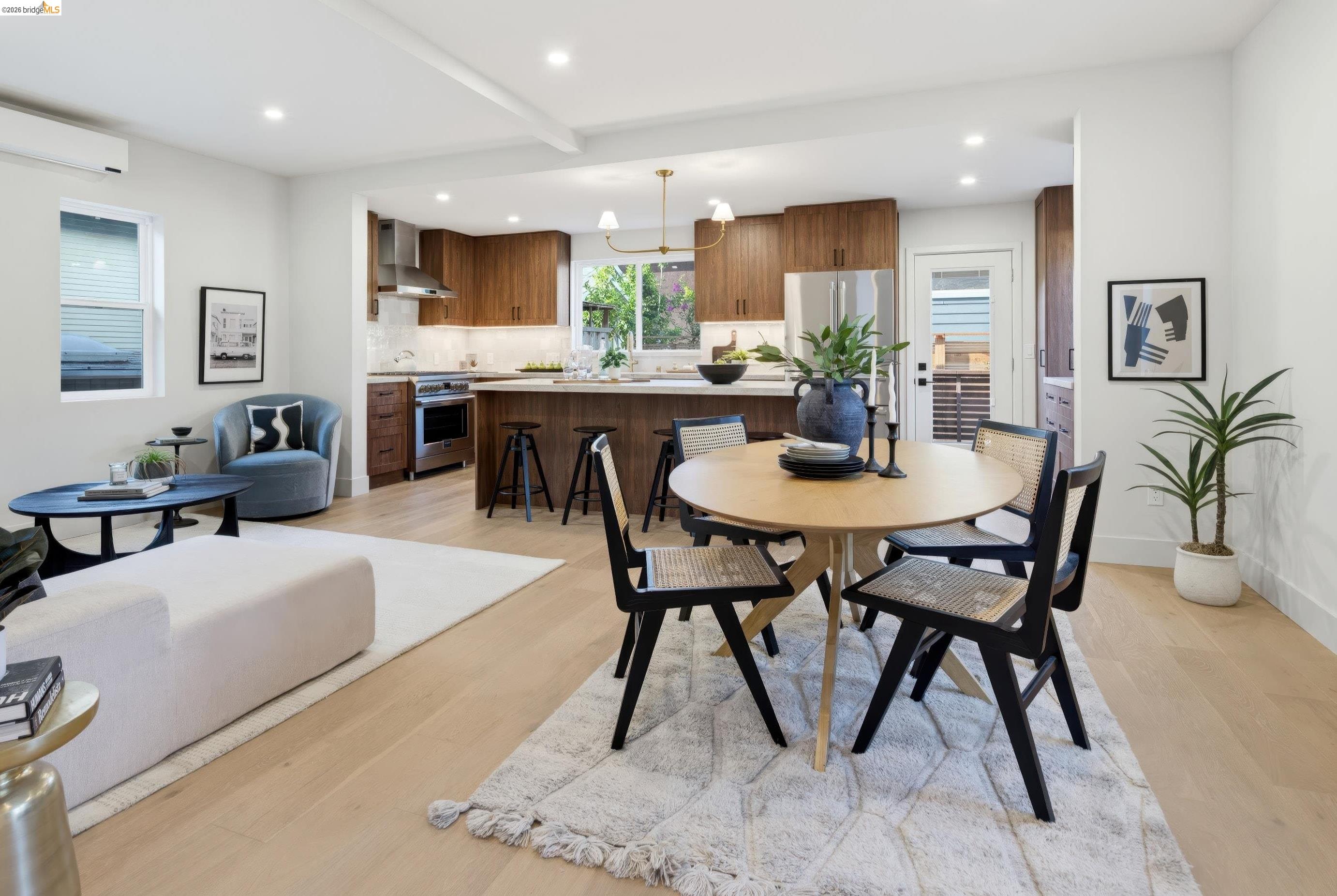 Open-plan kitchen and dining area with warm wood cabinetry, island seating, and a round table.