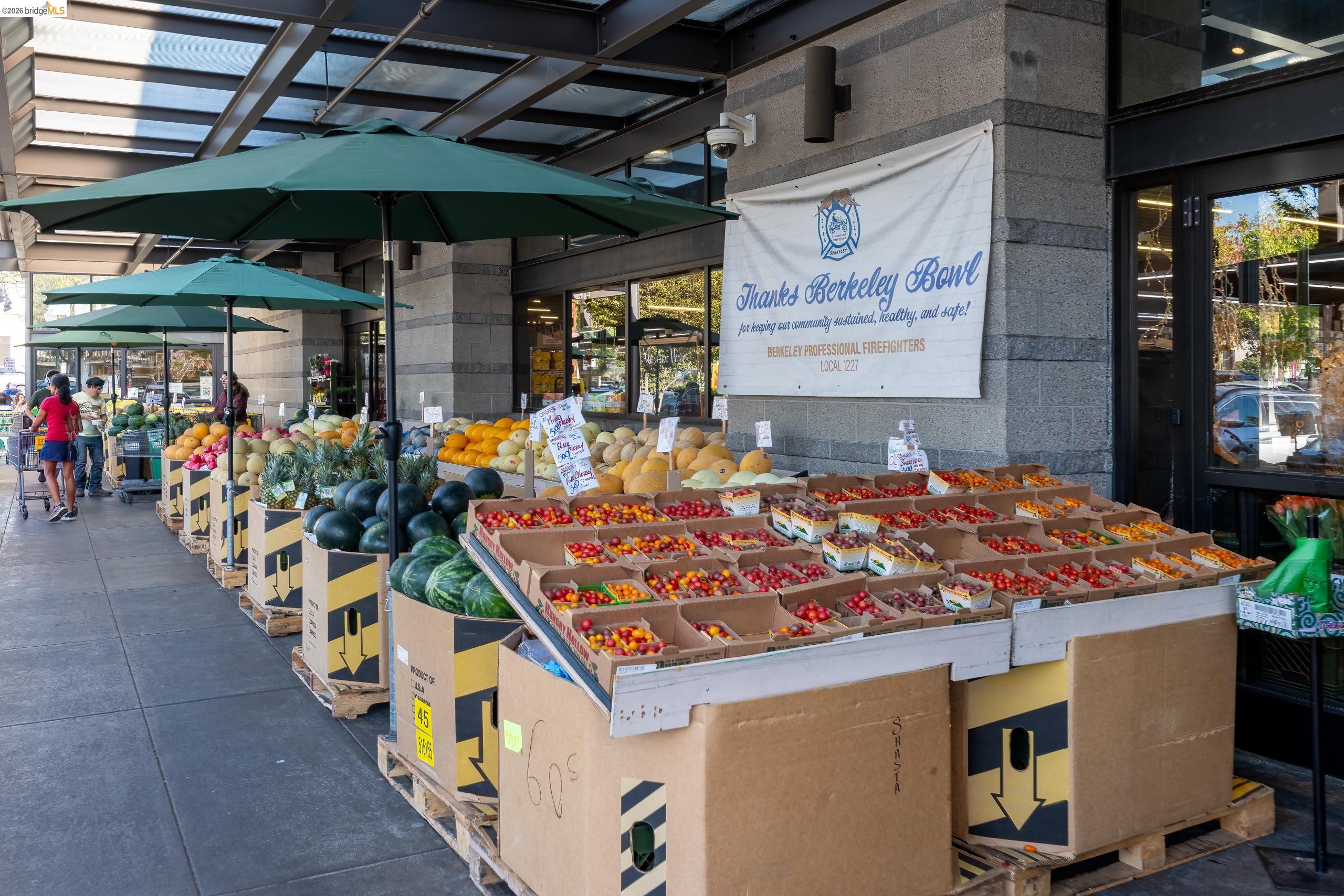 Berkeley Bowl storefront with outdoor produce displays and green umbrellas.