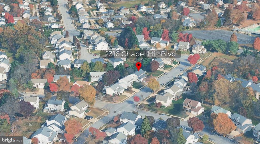 Aerial view of 2316 Chapel Hill Boulevard among homes and autumn trees.