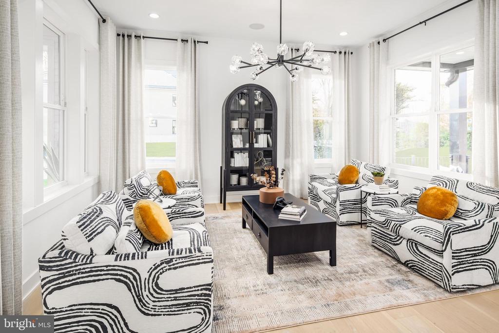 Staged living room with zebra-patterned sofas, mustard pillows, and an arched black display cabinet.