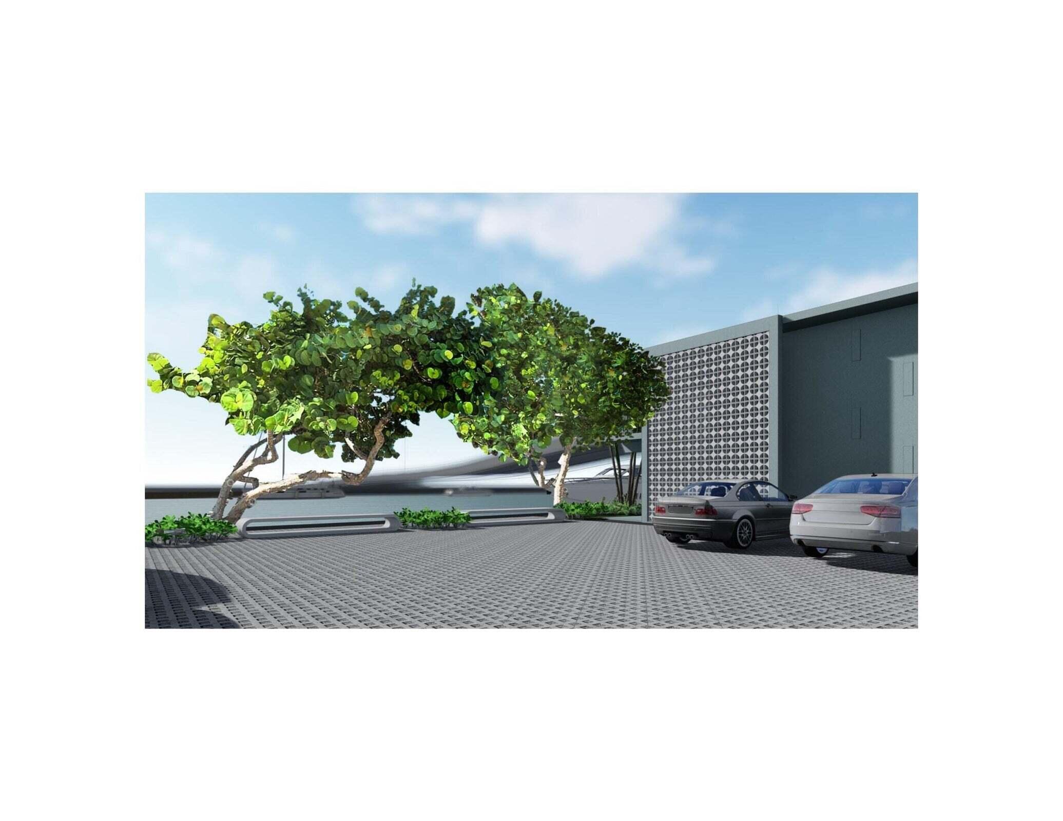 Modern building exterior with a patterned facade, parking area, parked cars, and leafy trees.