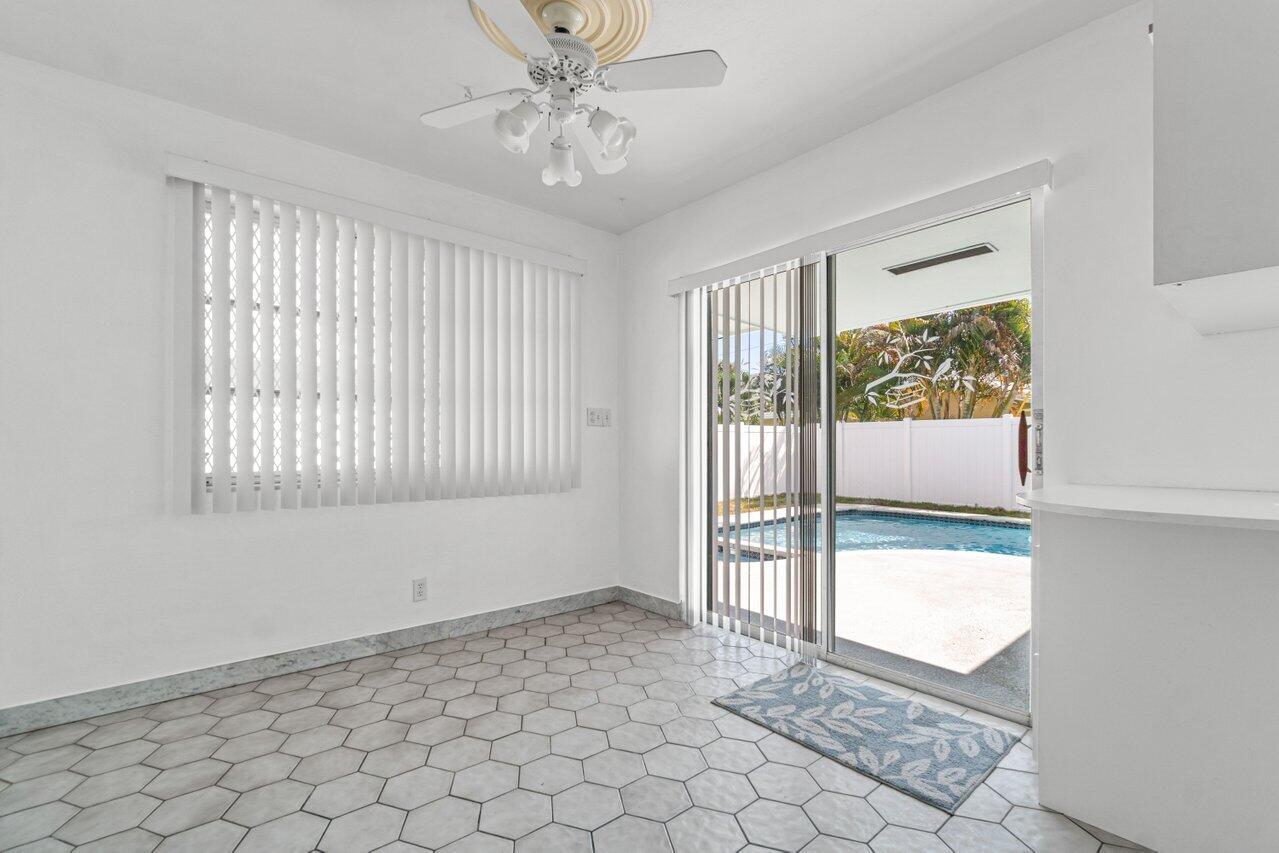 Kitchen area with hexagonal tile floors and sliding doors opening to a pool patio.