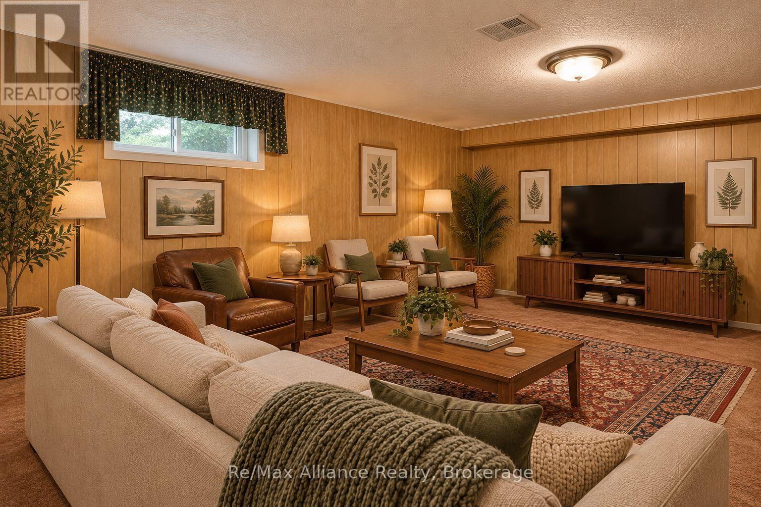 Staged living room with wood-paneled walls, a large TV, cream sofas and a patterned rug.