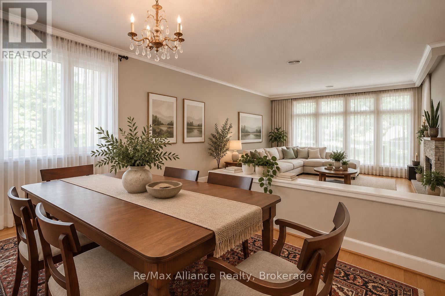 Dining room with a long wooden table opening onto a bright living room with a cream sectional.