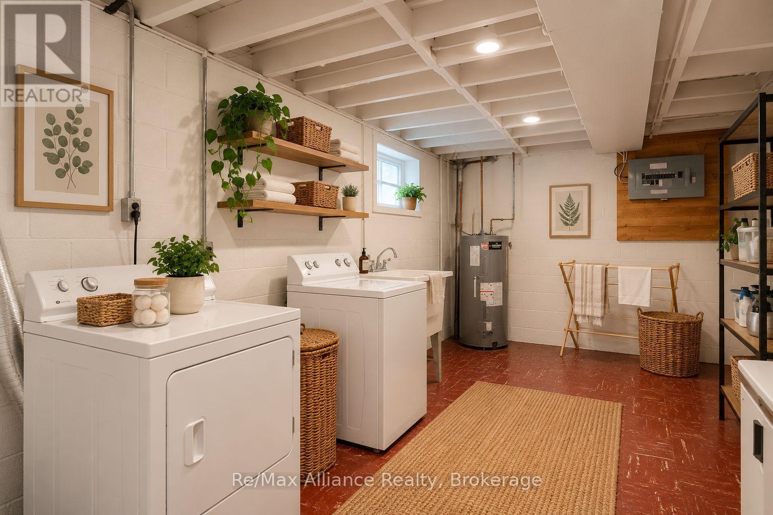 Basement laundry room with white washer and dryer, open shelves, and a woven rug.