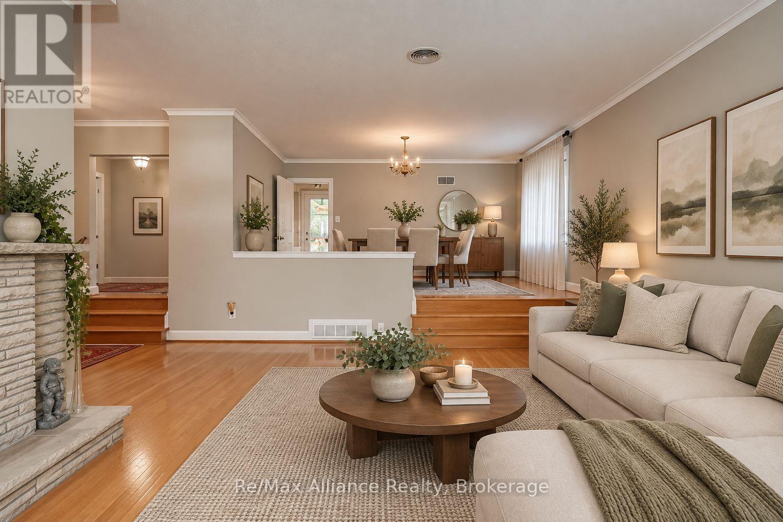 Living room with a beige sectional, round coffee table, fireplace, and raised dining area.