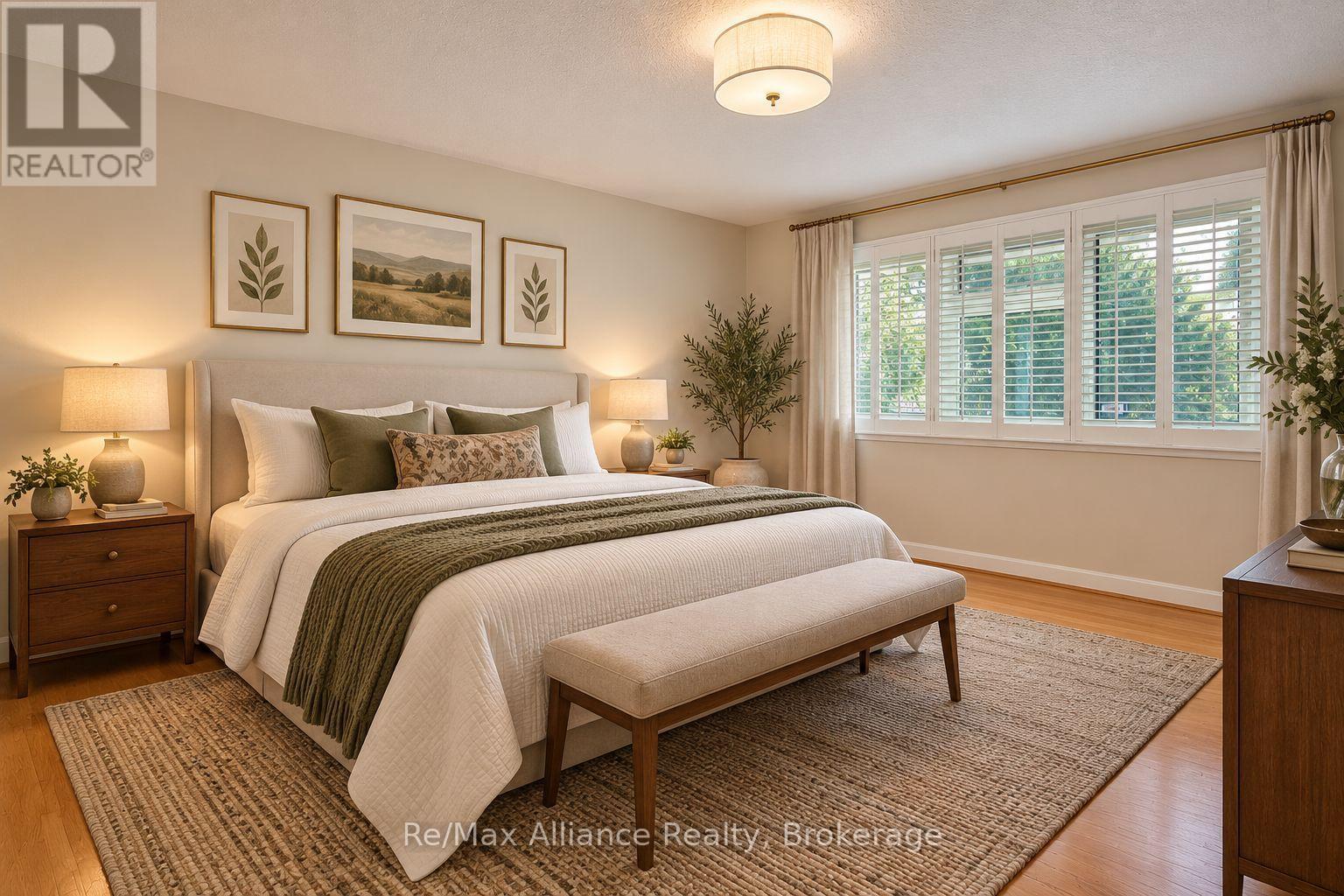 Bedroom with a white bed, olive-green throw, cushioned bench, and wide shuttered window.