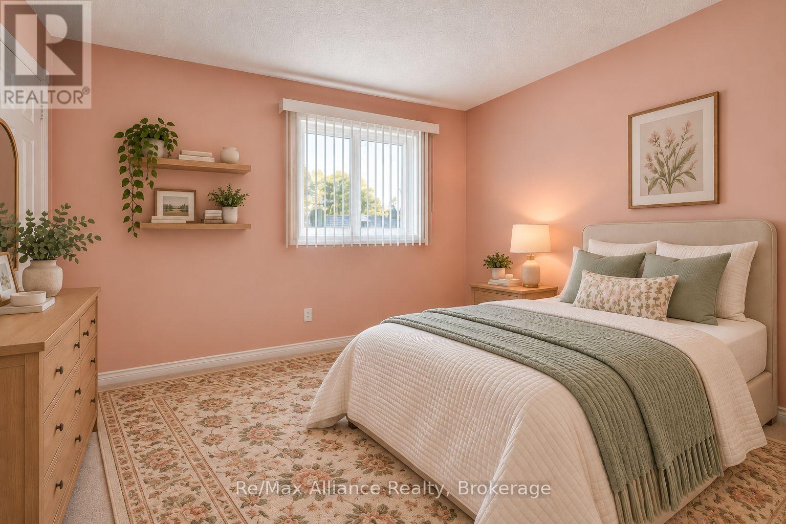 Bedroom with peach walls, a white bed with sage-green bedding, and a floral rug.