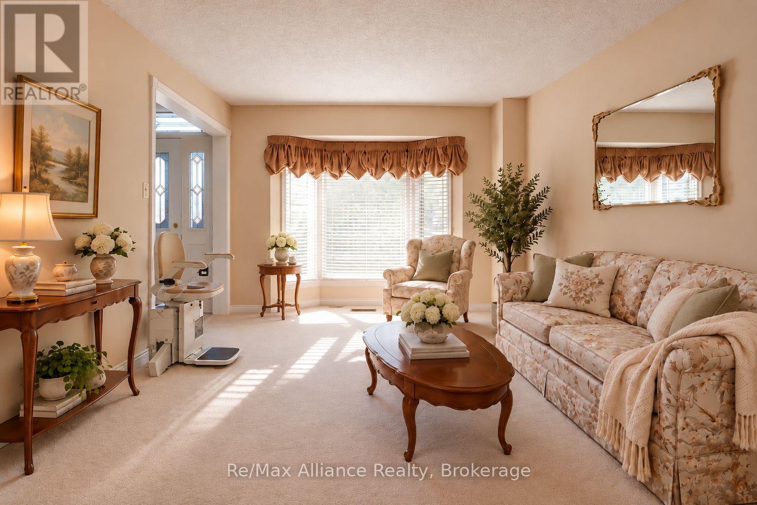 Living room with floral seating, traditional wood furniture, and a bright window with gathered curtains.