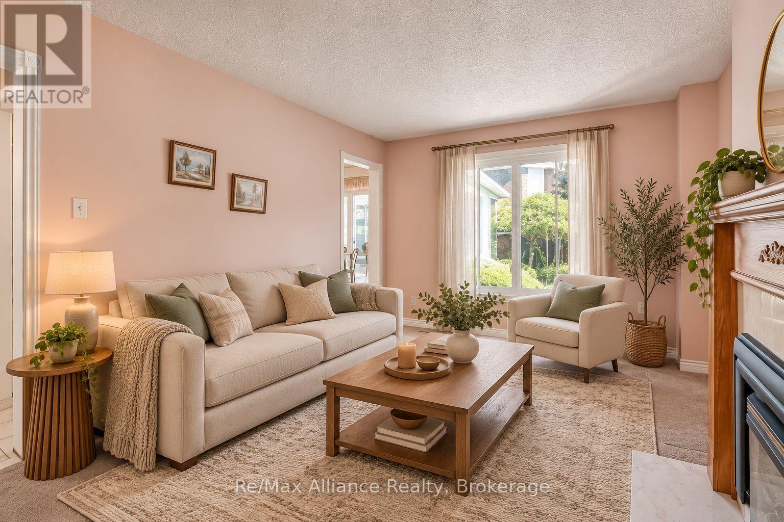 Furnished living room with a cream sofa, wood coffee table, and large window overlooking greenery.