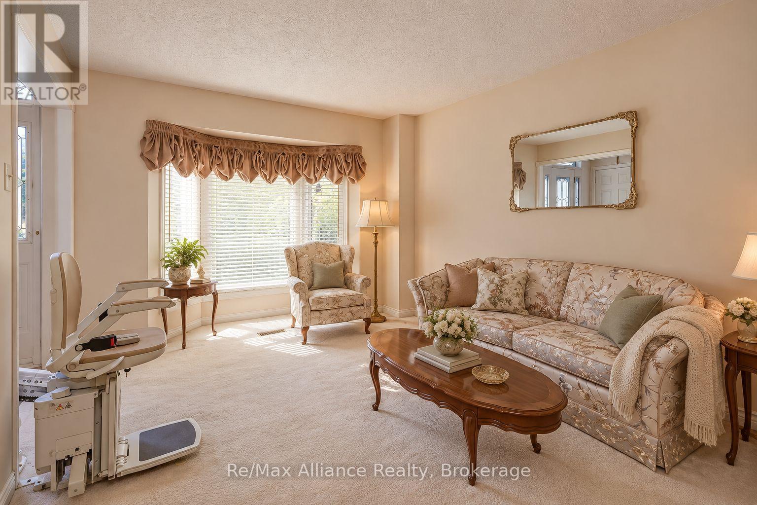 Living room with floral seating, a wooden coffee table, and an exercise machine by the window.