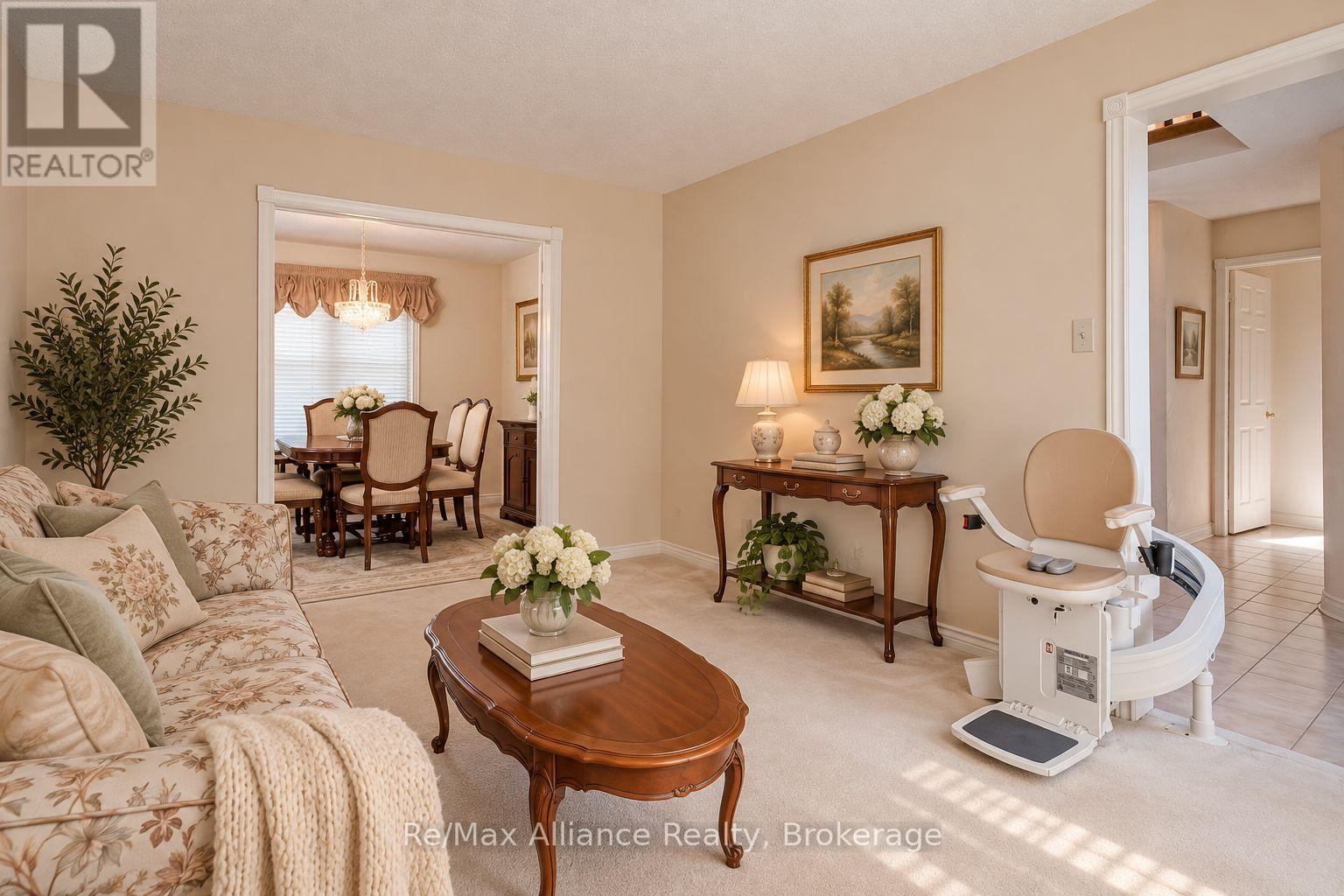 Living room with a floral sofa, wood coffee table, and stair lift beside the hallway.