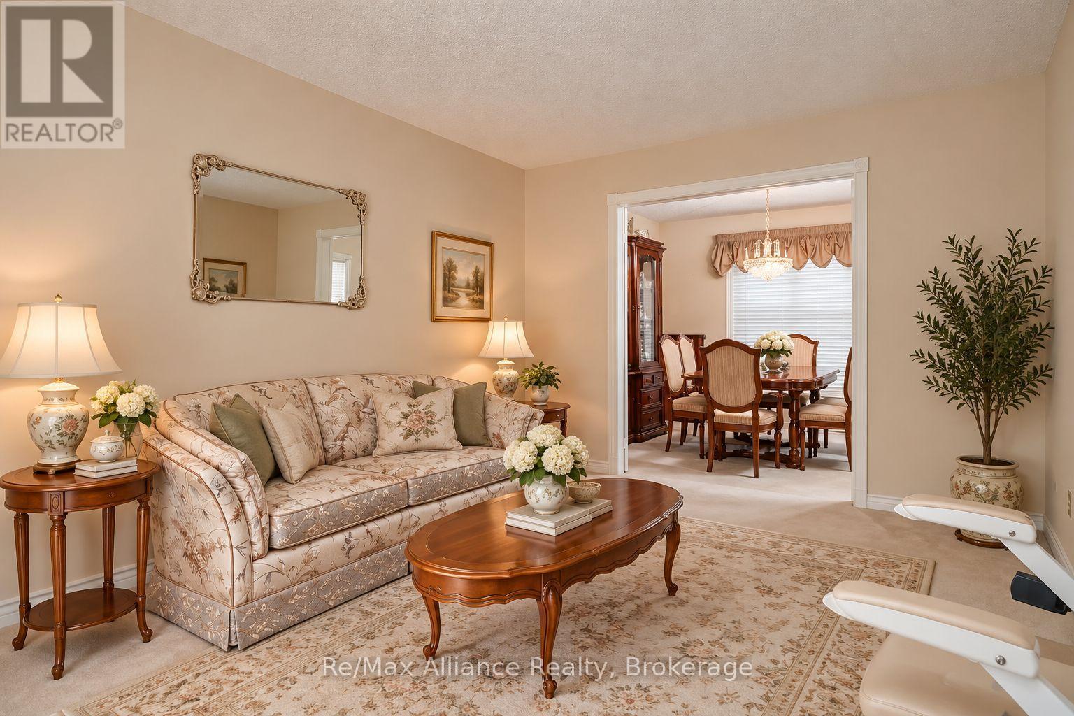 Furnished living room with a patterned sofa and an open view into a formal dining room.