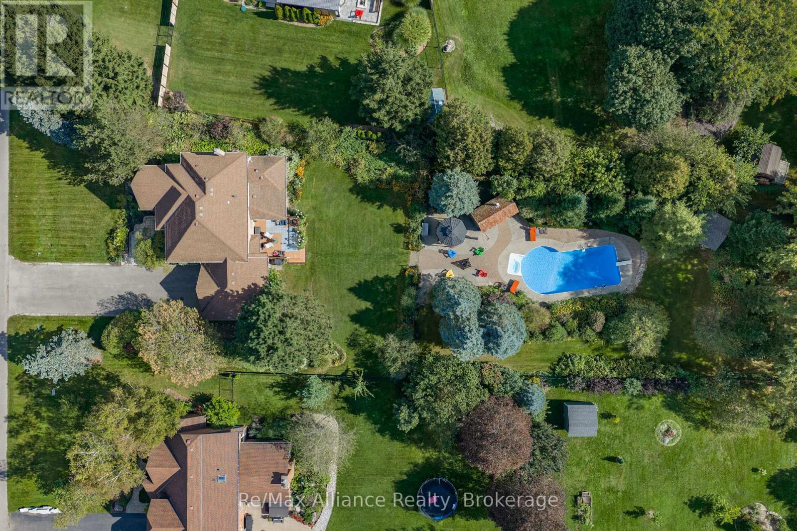 Aerial view of a home with a large landscaped yard and a backyard pool.