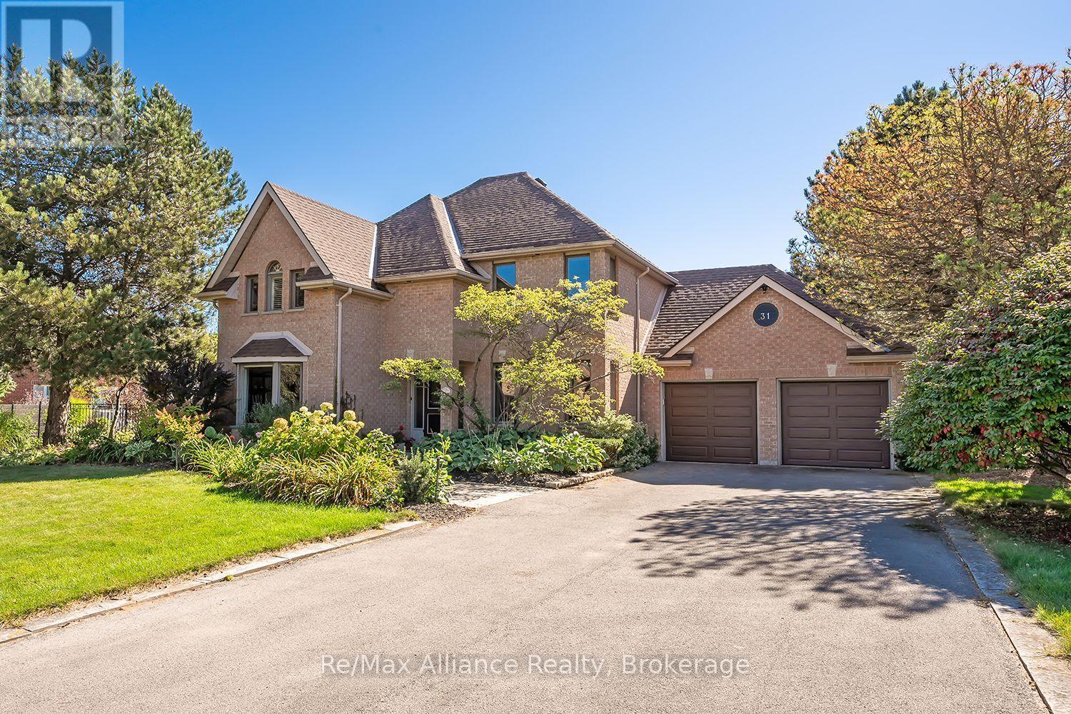 Two-story brick home with a double garage, landscaped front garden, and wide driveway.