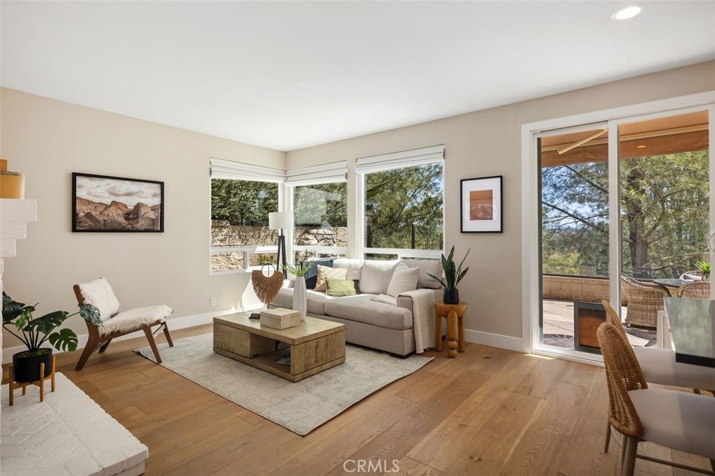 Living room with a beige sofa, wood coffee table, and windows overlooking a covered patio.